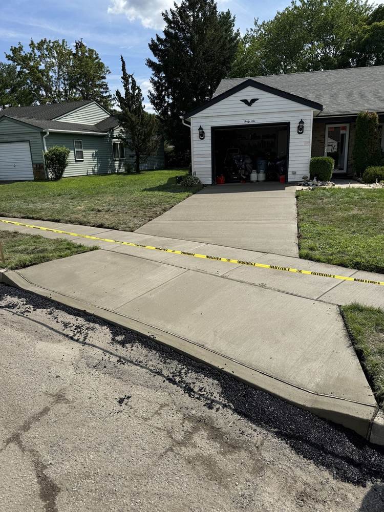 Concrete driveway apron at a garage, taped off while curing by South Jersey Construction Enterprise