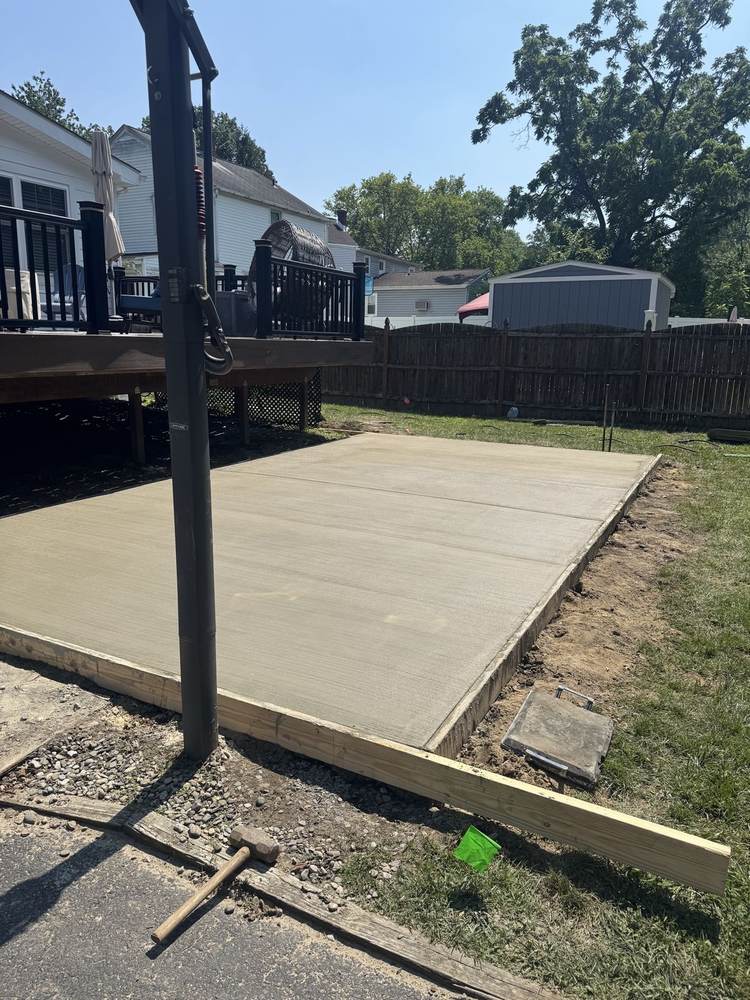 New concrete driveway installed by South Jersey Construction Enterprise at a townhouse garage, curing behind caution tape