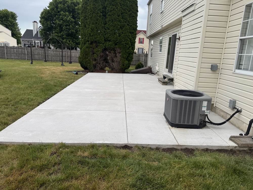 Backyard concrete patio poured beside a home by South Jersey Construction Enterprise