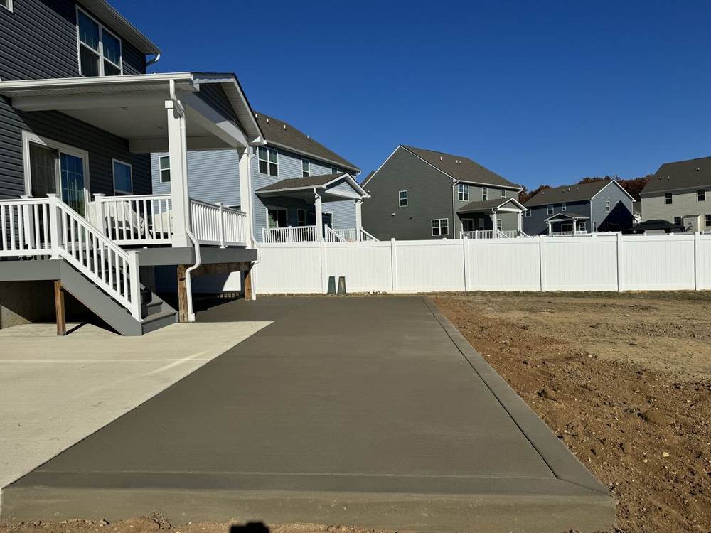 Concrete patio extension installed beside a covered porch by South Jersey Construction Enterprise