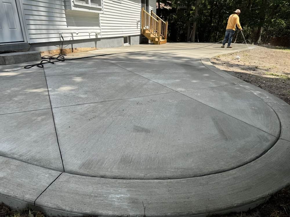 Large curved concrete patio being water-cured after finishing by South Jersey Construction Enterprise