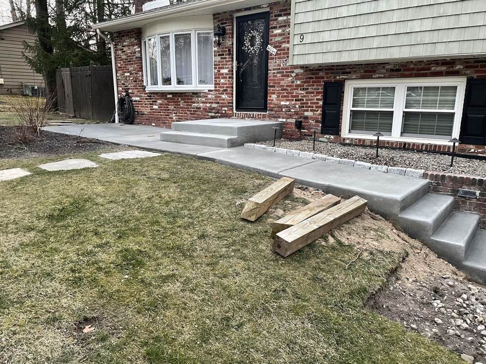 Concrete patio extension installed beside a house by South Jersey Construction Enterprise