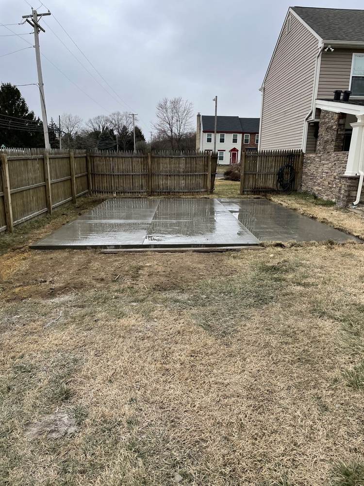 Fresh concrete patio pad installed in a fenced backyard by South Jersey Construction Enterprise