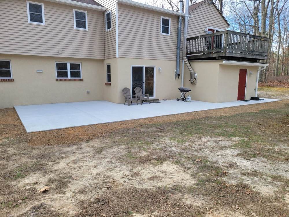 Large cured concrete patio installed beside a house by South Jersey Construction Enterprise