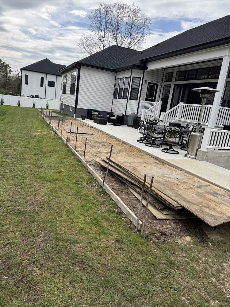 Patio extension prep: formed bed with rebar and plywood protection sheets by South Jersey Construction Enterprise