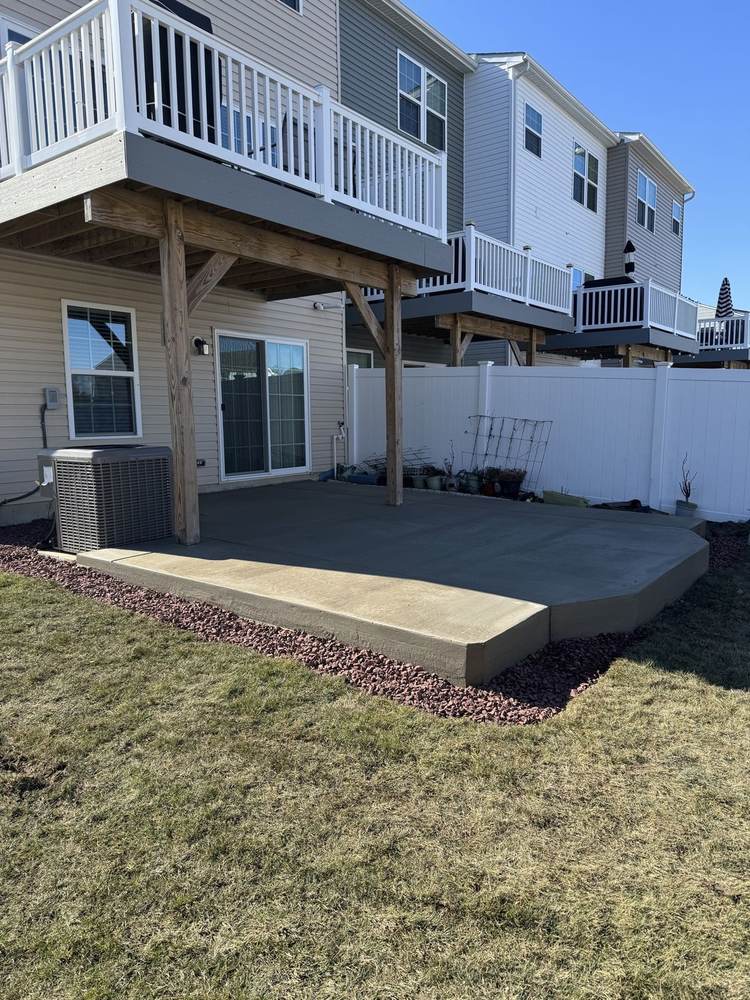 Concrete patio poured under an elevated deck at a townhouse by South Jersey Construction Enterprise