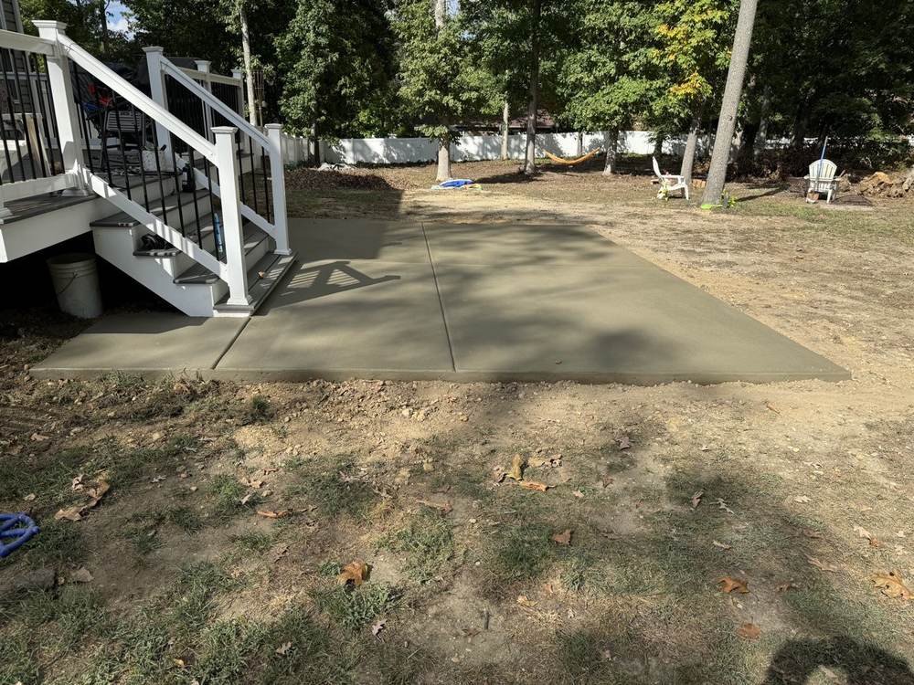 Concrete patio installed under a raised deck by South Jersey Construction Enterprise