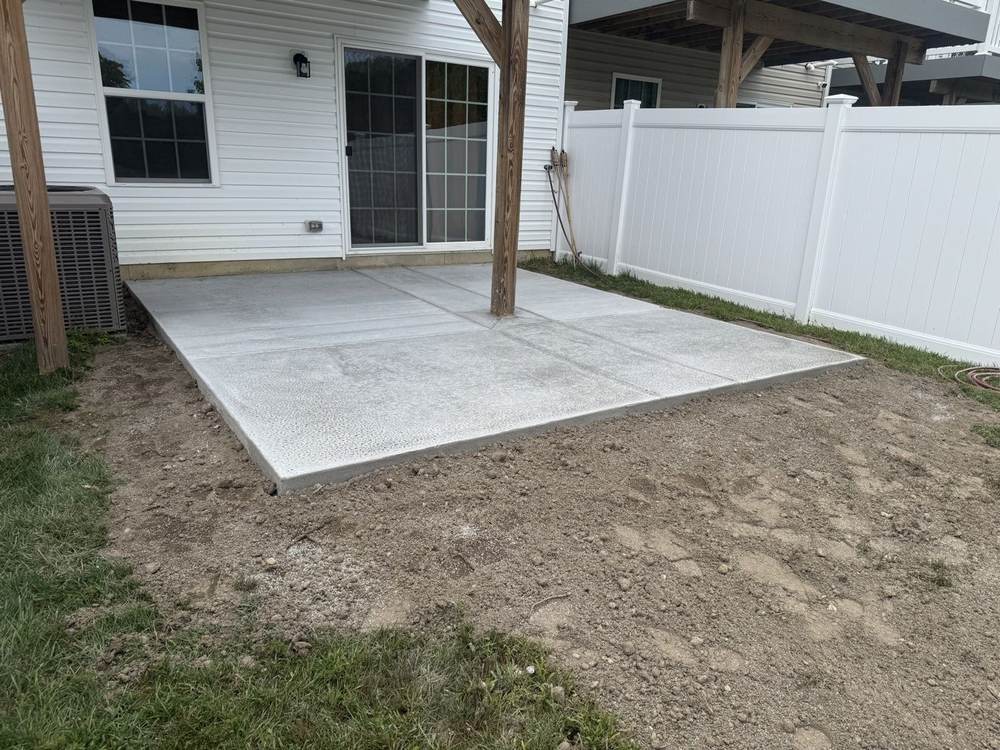 New concrete patio installed by South Jersey Construction Enterprise beside a white vinyl fence
