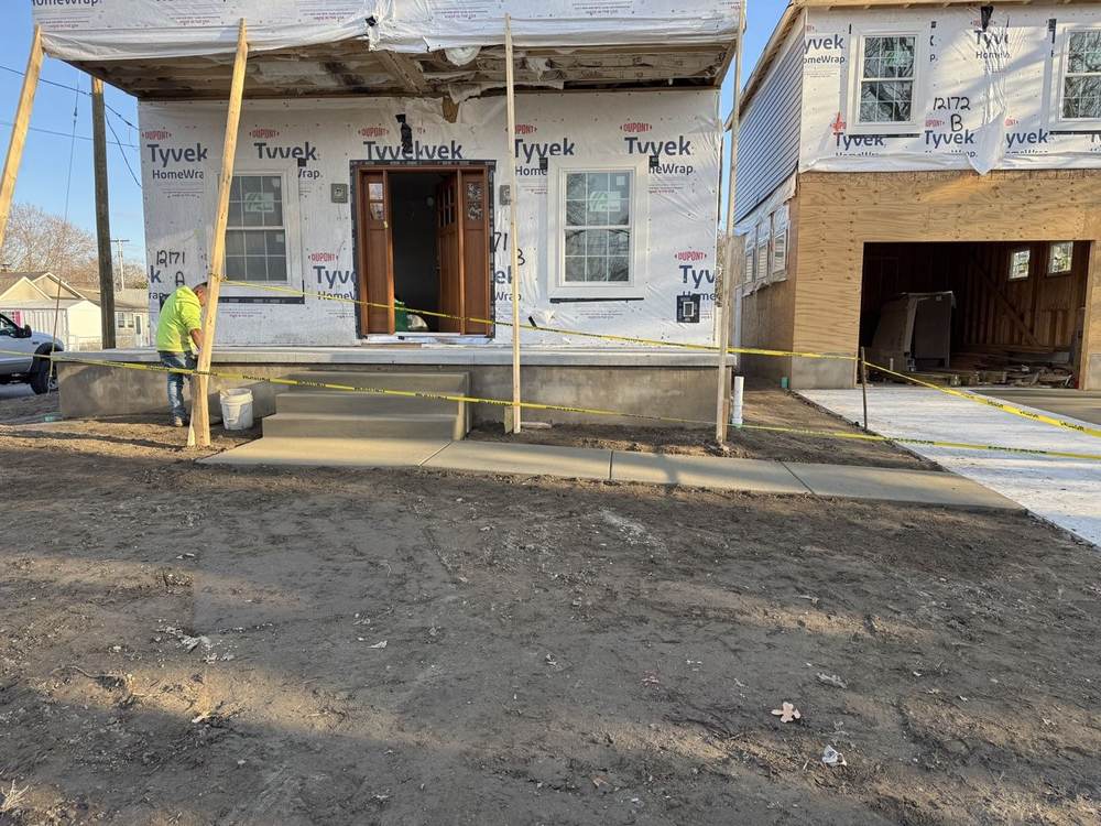Fresh concrete porch steps and walkway being finished at a new home by South Jersey Construction Enterprise