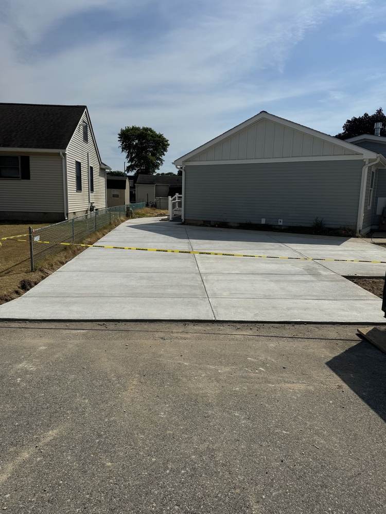 New concrete sidewalk installed by South Jersey Construction Enterprise running to the street, work truck parked alongside