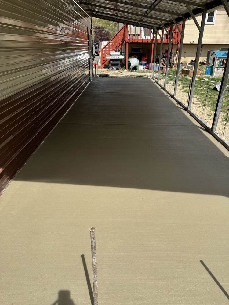 Smooth concrete slab under a metal carport by South Jersey Construction Enterprise