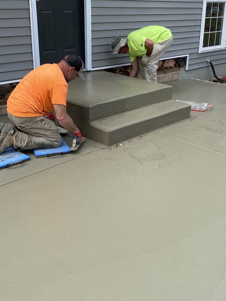 South Jersey Construction Enterprise crew hand-finishing fresh concrete steps and patio