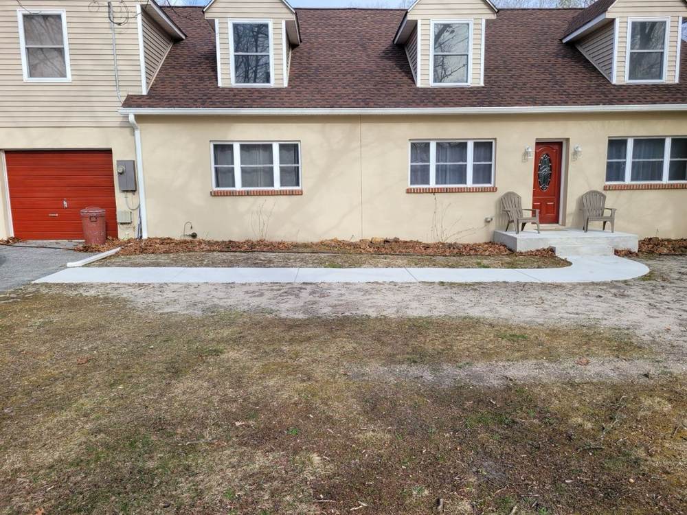 Curved concrete walkway with entry stoop installed by South Jersey Construction Enterprise