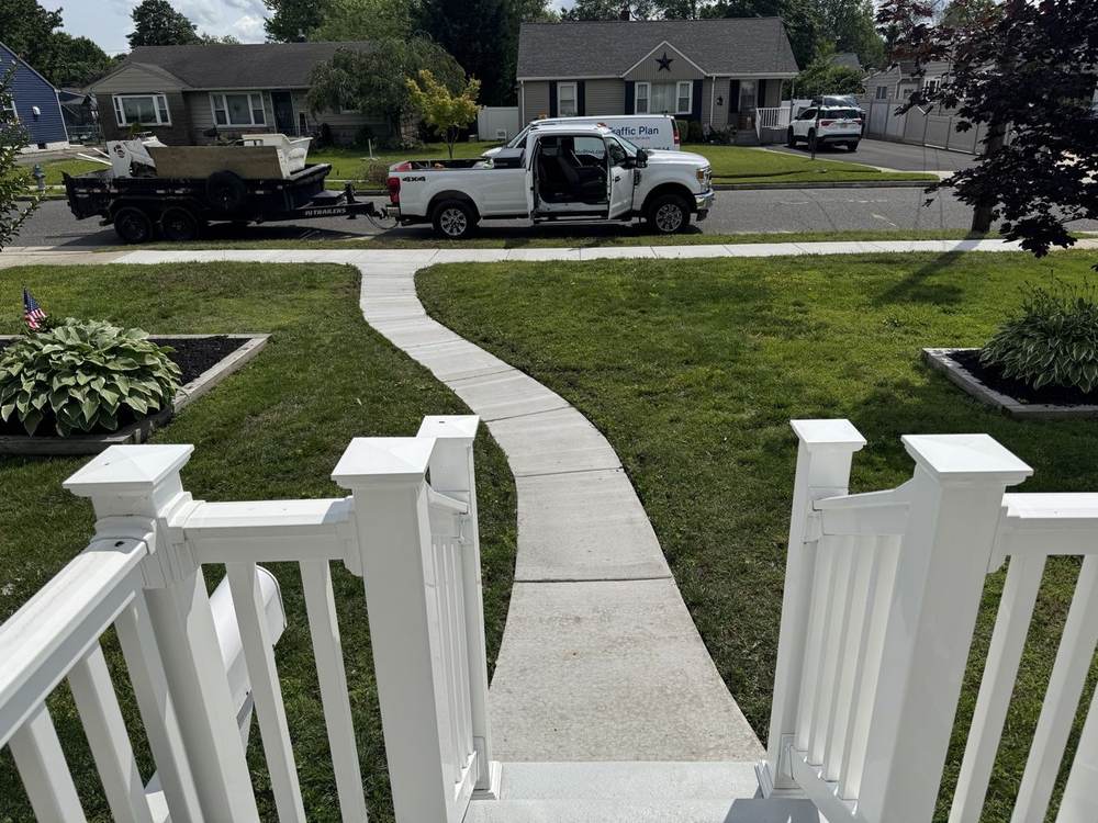 Curved concrete walkway from porch to street by South Jersey Construction Enterprise