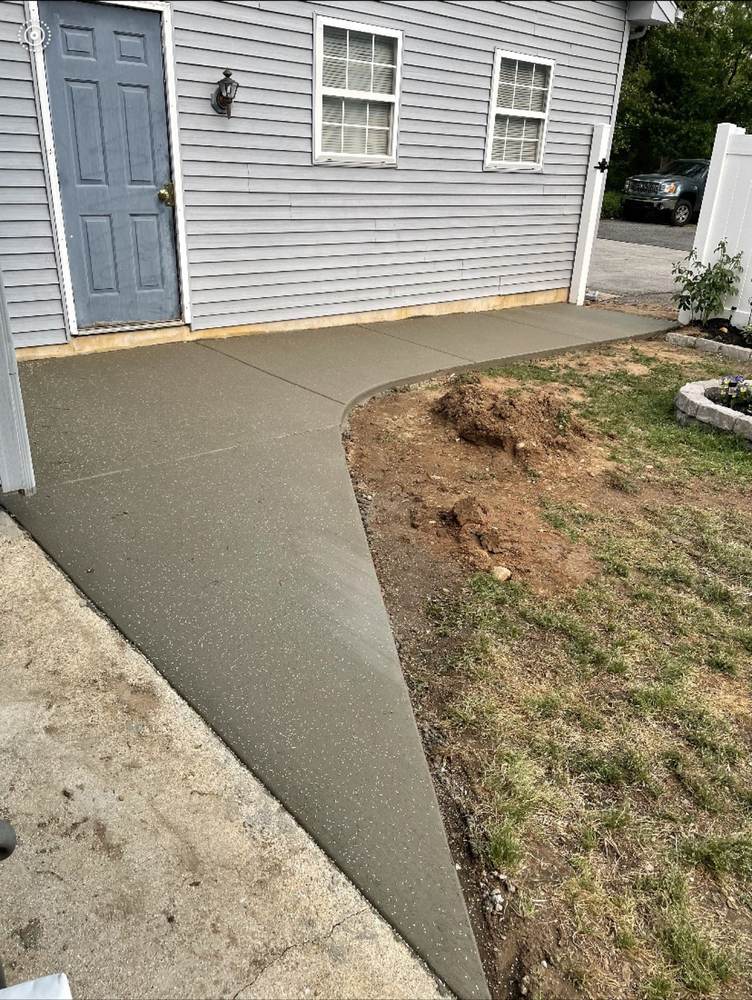 New concrete walkway to a side door installed by South Jersey Construction Enterprise beside a gray house
